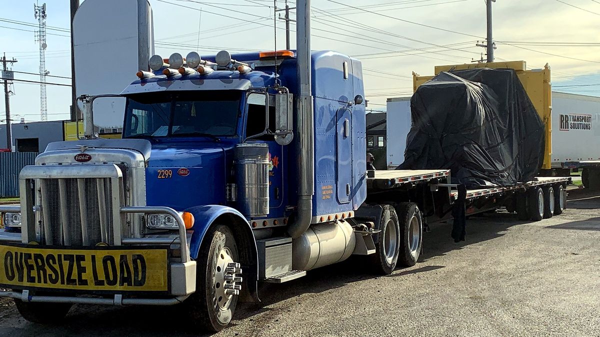 Pacific Prairie truck hauling a tarped oversize load on a flatdeck